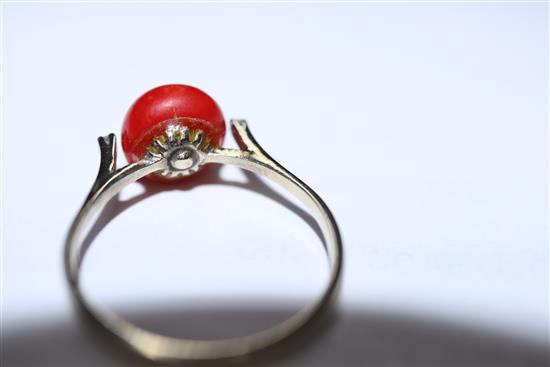 A 750 yellow metal, coral and diamond three stone ring, size O.